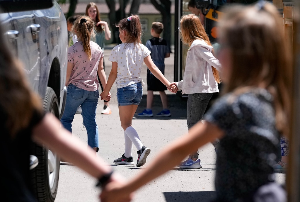 (Francisco Kjolseth | The Salt Lake Tribune) Individual classrooms hold hands as they exit school buses as students from Cedar Ridge Elementary participate in a reunification training drill, aimed to practice notifying parents of a child's location and condition in the event of a school shooting, at the Cache County Event Center in Logan on Friday, May 27, 2022.