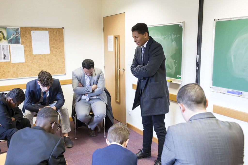 (The Church of Jesus Christ of Latter-day Saints)
A young man offers a prayer in a priesthood quorum meeting in Paris. The church has resumed the practice of opening second-hour Sunday meetings with prayer.