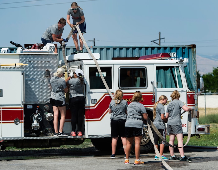 (Rick Egan  |  The Salt Lake Tribune)  Girl scouts and their leaders roll up the hoses, while attending Camp Fury.  A dozen Utah Girl Scouts participated in a 3-day camp led by female firefighters. Camp Fury Utah was developed in partnership with the Girl Scouts and local fire and police departments, designed to expose teen girls to careers in public safety and other non-traditional jobs. Saturday, August 5, 2017.


