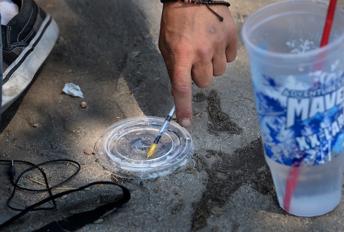 (Scott Sommerdorf | The Salt Lake Tribune) "Jonathan" mixes some black tar heroin with water and then draws into his needle as he prepares to shoot a dose on the median near 500 West & 300 South. August 3, 2017.