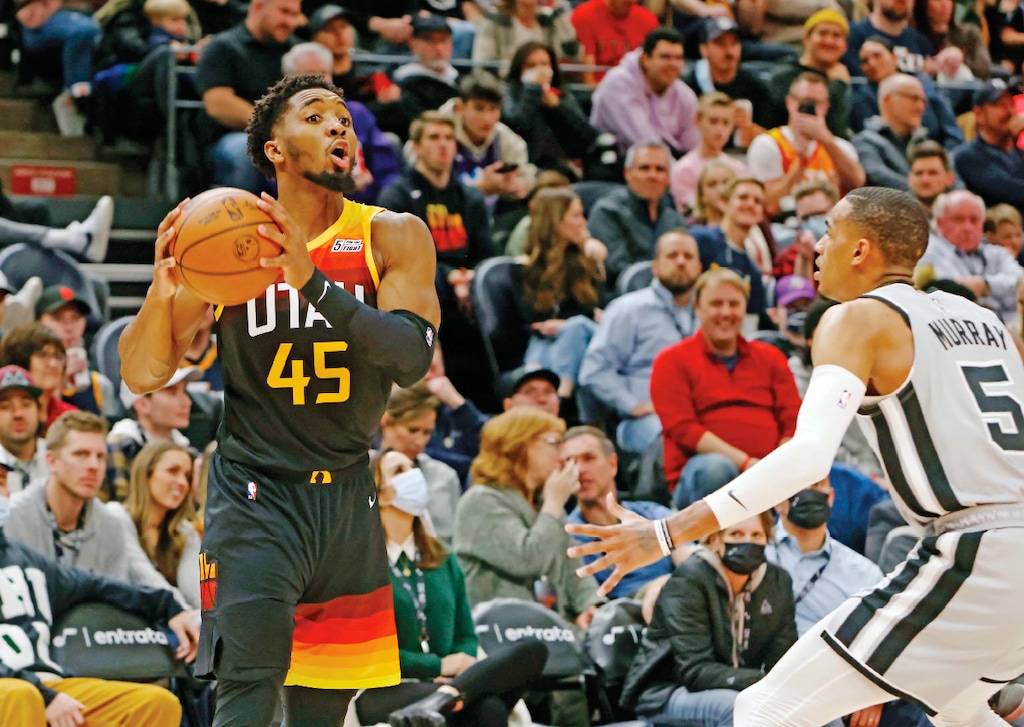 Utah Jazz guard Donovan Mitchell (45) looks to pass as San Antonio Spurs guard Dejounte Murray (5) defends during the first half of an NBA basketball game on Friday, Dec. 17 2021, in Salt Lake City. (AP Photo/Kim Raff)