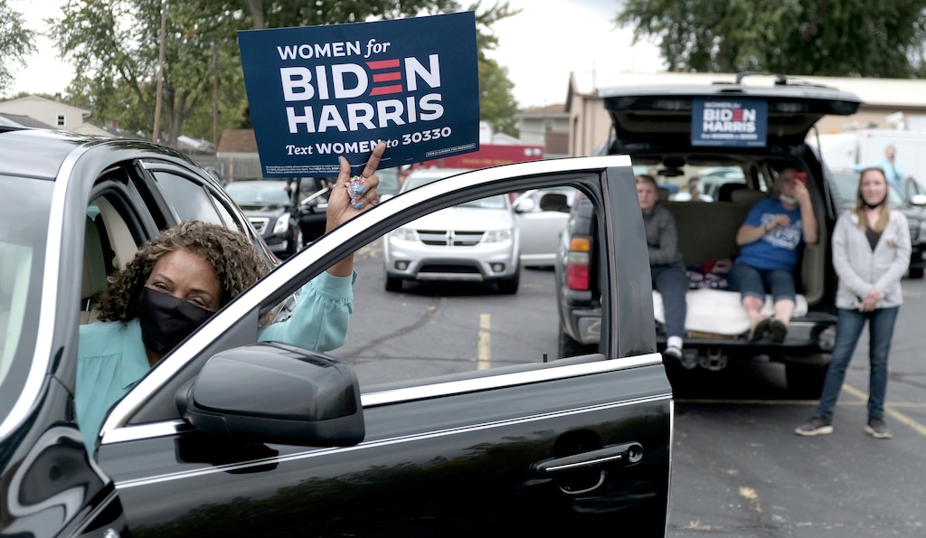 (Lori King | The Toledo Blade file photo via AP)  Mary Harris holds up a Women for Biden Harris sign during presidential candidate Joe Biden's speech at a drive-in rally at UAW Local 14 in Toledo, Ohio, on Monday, Oct. 12, 2020.