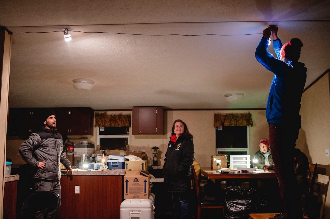 (Courtesy of Laura Dearden | Real Salt Lake Foundation) Real Salt Lake captain Kyle Beckerman (left), the Real Salt Lake Foundation's Mary VanMinde and photographer Mylo Fowler install solar-powered LED lights in a home in San Juan County in November 2019.