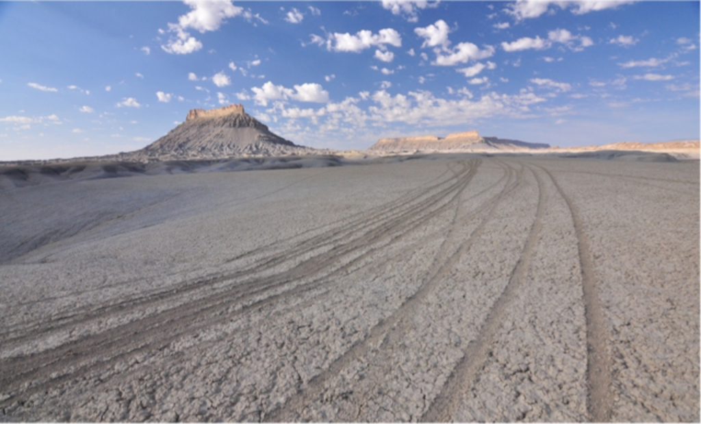 (Photo courtesy of Ray Bloxham, Southern Utah Wilderness Alliance) This photo shot in 2017 shows tracks left by illegal off-roading near Factory Butte, pictured in the distance. The BLM this week announced in May 2019 that it is reopening the lands encircling the famous southern Utah butte to cross-country motorized travel, and three environmental groups have since filed a lawsuit to close the land to motorized use.