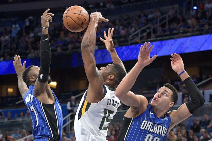 Orlando Magic forward Jonathon Simmons (17) and forward Aaron Gordon (00) combine to knock the ball out of the hands of Utah Jazz forward Derrick Favors (15) during the first half of an NBA basketball game Saturday, Nov. 18, 2017, in Orlando, Fla. (AP Photo/Phelan M. Ebenhack)