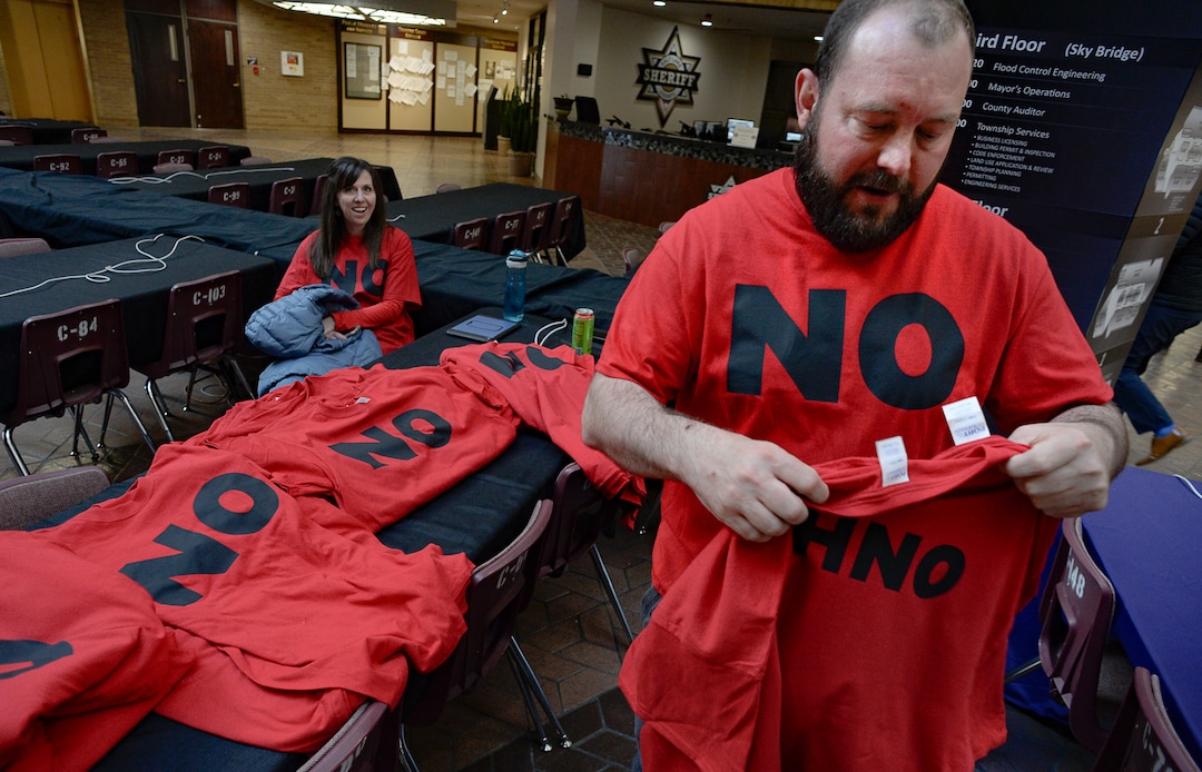 (Francisco Kjolseth  |  Tribune file photo) Teddy Hodges of Herriman, hands out shirts expressing opposition to the proposed Olympia Hills development prior to Salt Lake County Council taking the first of two votes on Tuesday, Feb. 25, 2020, on a set of zoning changes for the controversial new housing and commercial development proposed on unincorporated county land on Herriman's western border. The County Council approved the zoning changes 6-to-3, as residents from Herriman, Bluffdale and Riverton who oppose the project turned out for the hearing to voice their concerns.