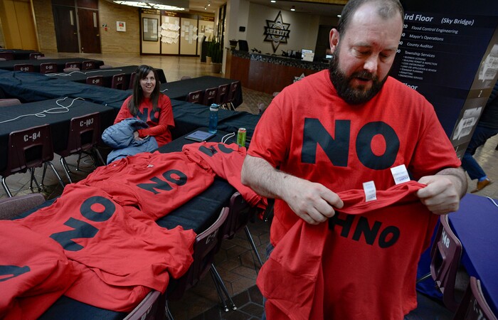 (Francisco Kjolseth | Tribune file photo) Teddy Hodges of Herriman, hands out shirts expressing opposition to the proposed Olympia Hills development prior to Salt Lake County Council taking the first of two votes on Tuesday, Feb. 25, 2020, on a set of zoning changes for the controversial new housing and commercial development proposed on unincorporated county land on Herriman's western border. The County Council approved the zoning changes 6-to-3, as residents from Herriman, Bluffdale and Riverton who oppose the project turned out for the hearing to voice their concerns.