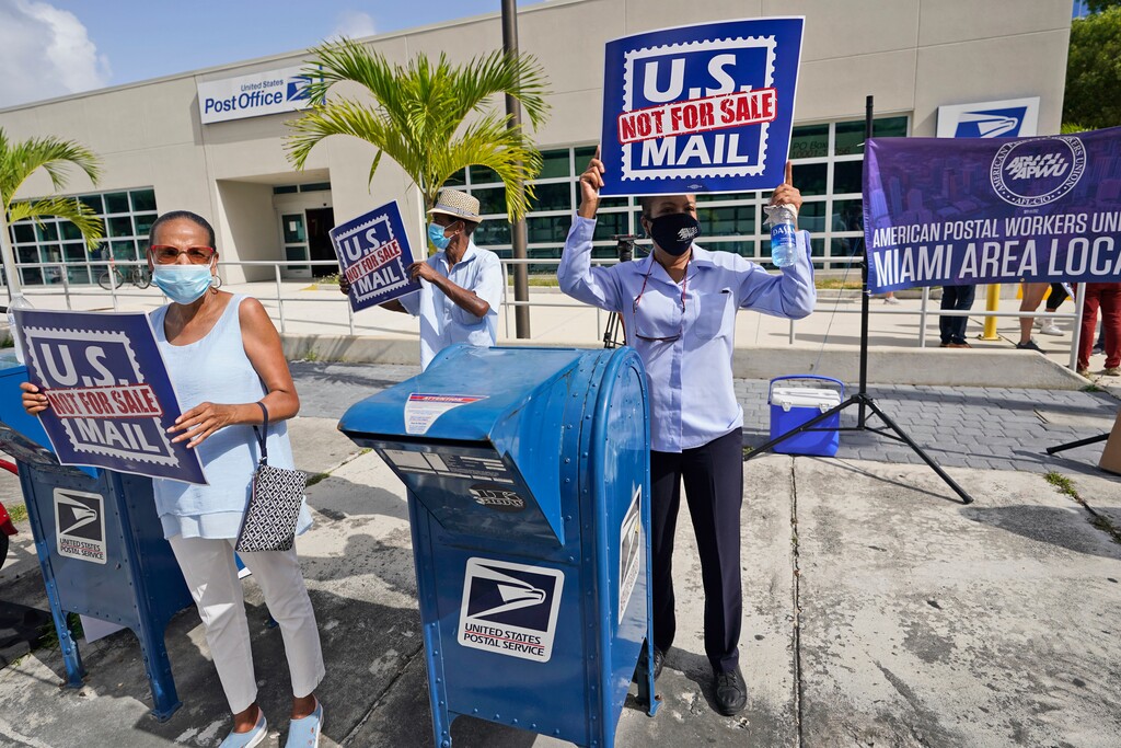 (Wilfredo Lee | AP file photo)  Protesters demonstrate during a "National Day of Action to Save the 'Peoples' Post Office!" outside the Flagler Station post office, Tuesday, Aug. 25, 2020, in Miami.