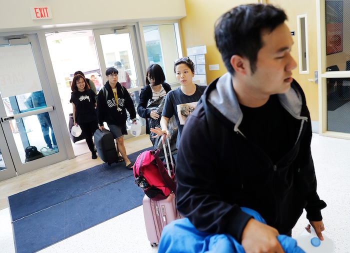 (AP Photo/David Goldman) Linh Cao, second from right, and Huy Nguyen, right, enter a shelter at Florida International University with fellow students after being evacuated from their dorm ahead of Hurricane Irma in Miami, Saturday, Sept. 9, 2017.