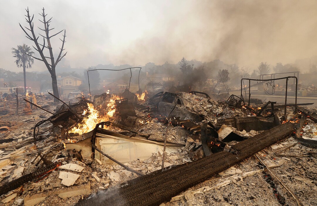 Flames rise from the remains of a house that burned down in Santa Rosa, Calif., Monday, Oct. 9, 2017. Wildfires whipped by powerful winds swept through Northern California, sending residents on a headlong flight to safety through smoke and flames as homes burned. (AP Photo/Jeff Chiu)