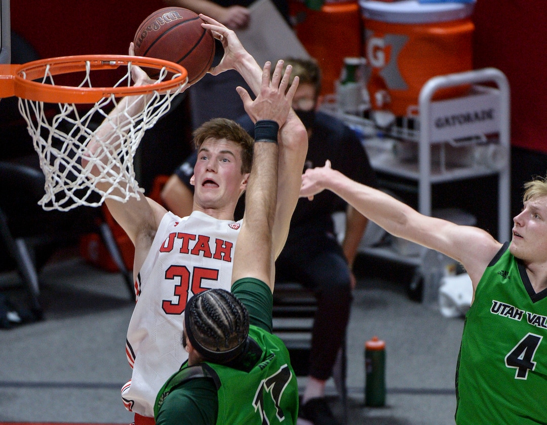 (Leah Hogsten  |  The Salt Lake Tribune) Utah Utes center Branden Carlson (35) shoots around Utah Valley Wolverines center Fardaws Aimaq (11) as the Utes host Utah Valley University on Tuesday, Dec. 15, 2020 at the Jon M. Huntsman Center. The Utes won 75-67.