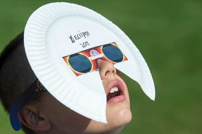 (Rick Egan  |  The Salt Lake Tribune)  Oaklen Lawrence, 9, of Idaho Falls, watches the early stages of the solar eclipse at Melaleuca Baseball Park, in Idaho Falls, Monday, August 21, 2017.