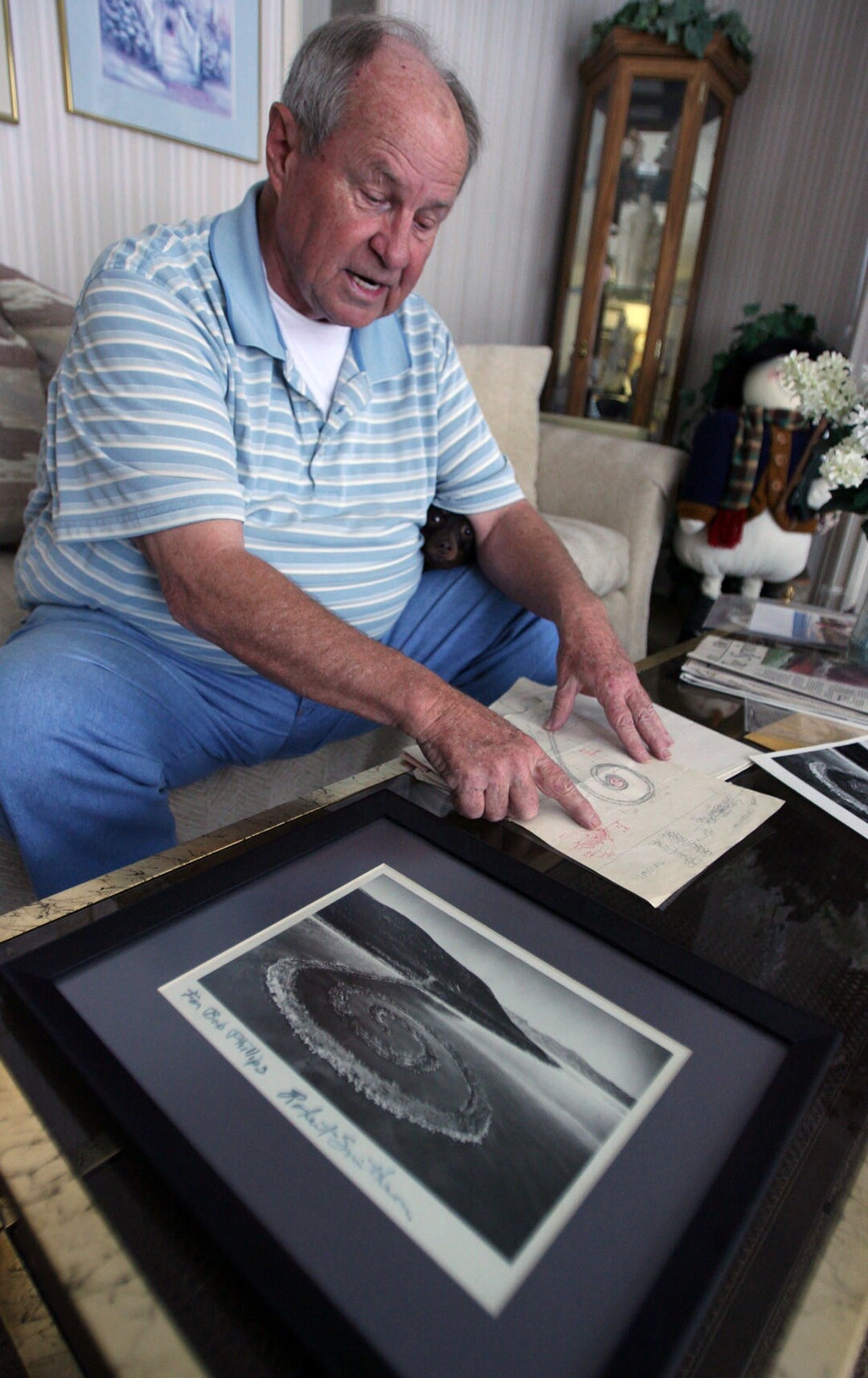 (Steve Griffin  |  The Salt Lake Tribune) Bob Phillips looks over photos and original designs for the Spiral Jetty  in his Ogden home Thursday, Feb. 24, 2011.  Phillips was the contractor who built the Spiral Jetty for artist Robert Smithson.