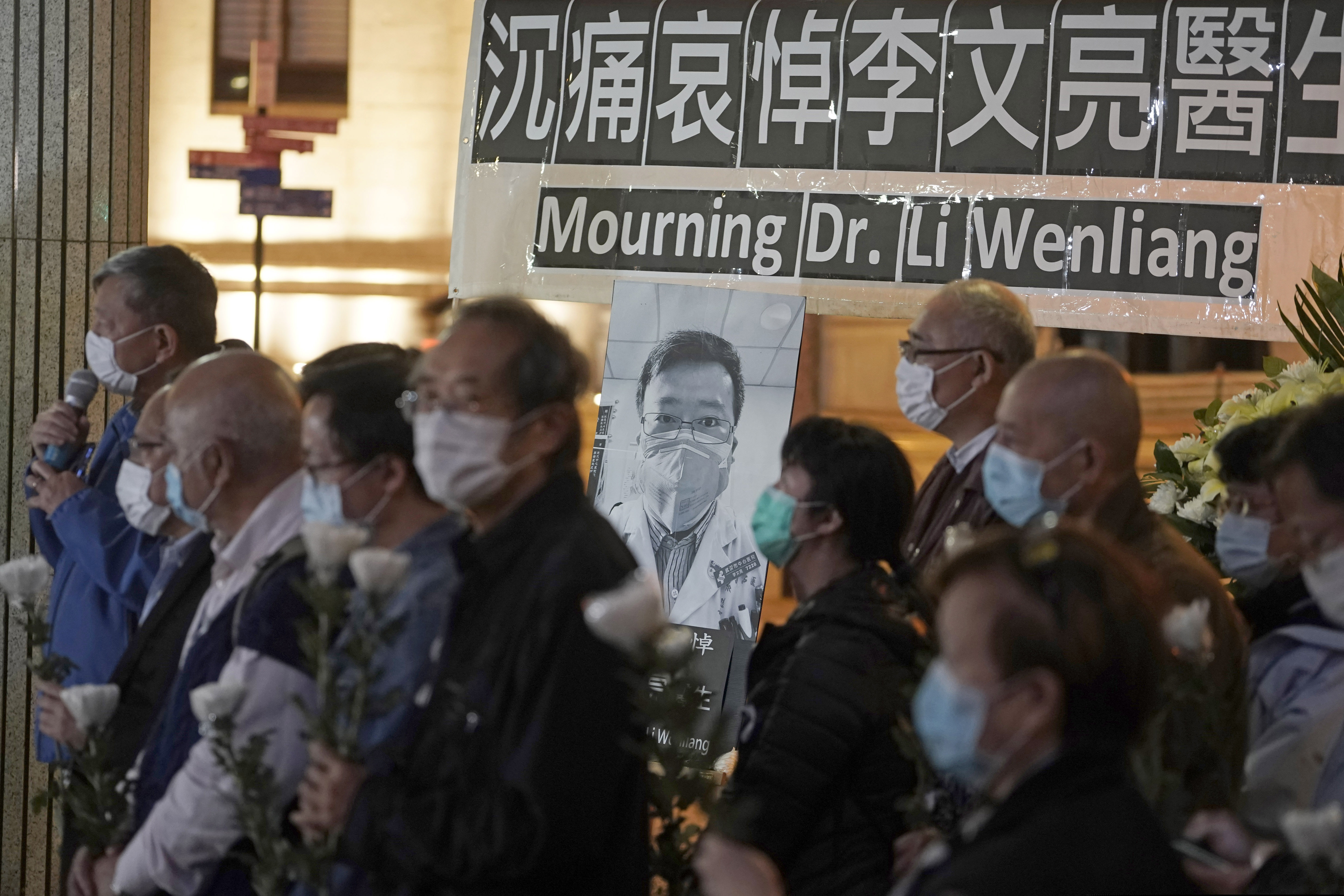 (Kin Cheung | AP) People wearing masks, attend a vigil for late Chinese doctor Li Wenliang, in Hong Kong, Friday, Feb. 7, 2020. The death of a young doctor who was reprimanded for warning about China's new virus triggered an outpouring Friday of praise for him and fury that communist authorities put politics above public safety.