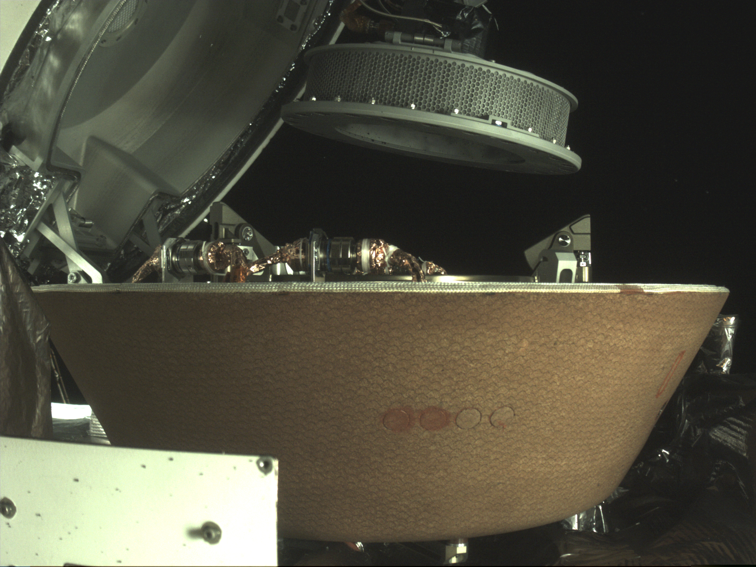 (NASA via AP) In this undated image provided by NASA, a sample container hovers over a capsule on the Osiris-Rex spacecraft near the asteroid Bennu. The capsule will eventually return to Earth with rubble collected in the container on Oct. 20, 2020, from the asteroid’s surface.