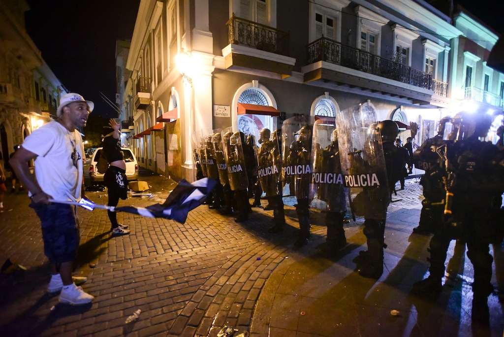 (Carlos Giusti | AP Photo)Demonstrators stand in front of riot control units during clashes in San Juan, Puerto Rico, Monday, July 22, 2019. Protesters are demanding Gov. Ricardo Rossello step down following the leak of an offensive, obscenity-laden online chat between him and his advisers that triggered the crisis.