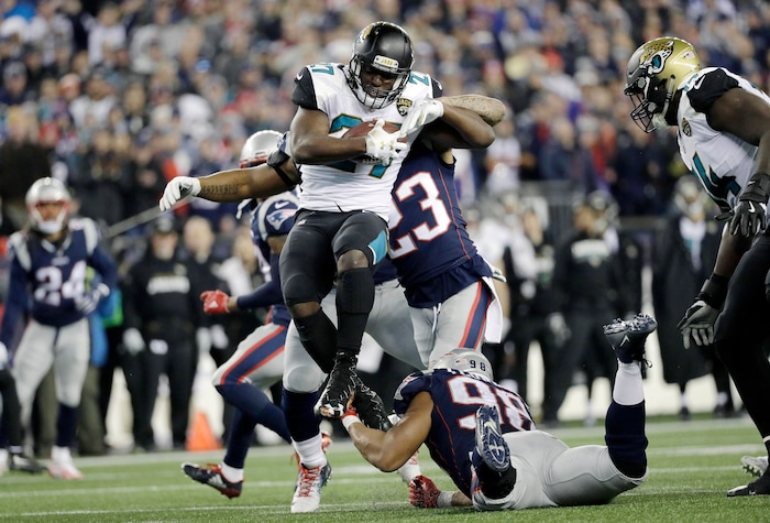 Jacksonville Jaguars running back Leonard Fournette (27) leaps over New England Patriots defensive end Trey Flowers (98) during the second half of the AFC championship NFL football game, Sunday, Jan. 21, 2018, in Foxborough, Mass. (AP Photo/David J. Phillip)