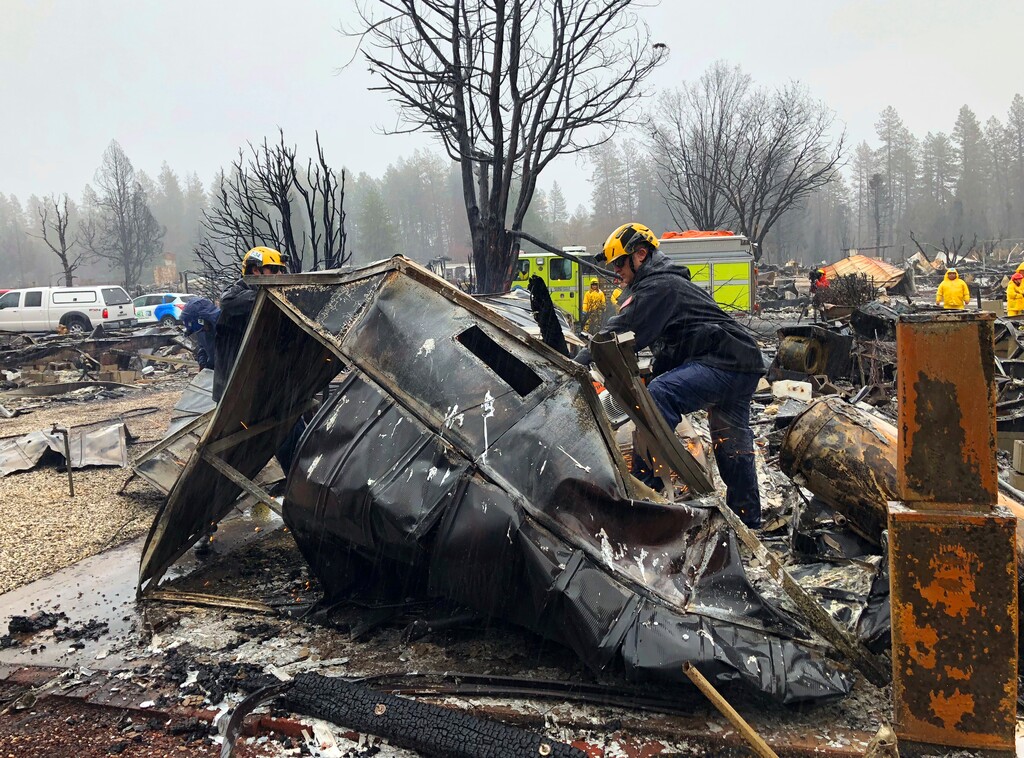 (Kathleen Ronayne | Associated Press) Steven McKnight, right, and Daniel Hansen saw through large pieces of sheet metal so they can be moved to allow cadaver dogs to search beneath them for signs of human remains at a mobile home park in Paradise, Calif., Friday, Nov. 23, 2018. They said the mobile home park had already been hand searched, so they were re-examining it with search dogs.