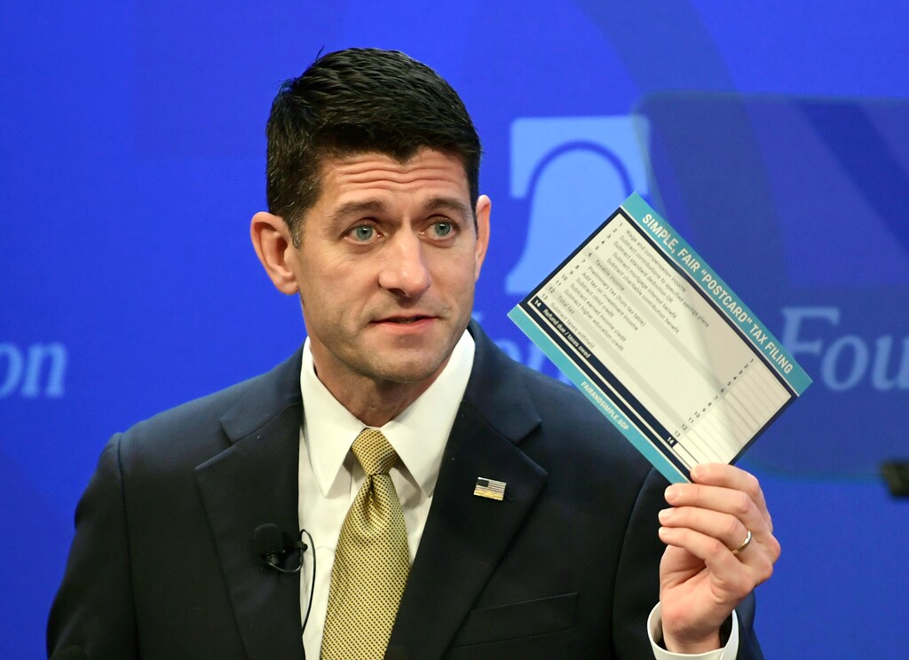 House Speaker Paul Ryan of Wis., holds up a copy of a proposed "simple tax" postcard while speaking at the Heritage Foundation in Washington, Thursday, Oct. 12, 2017. (AP Photo/Susan Walsh)
