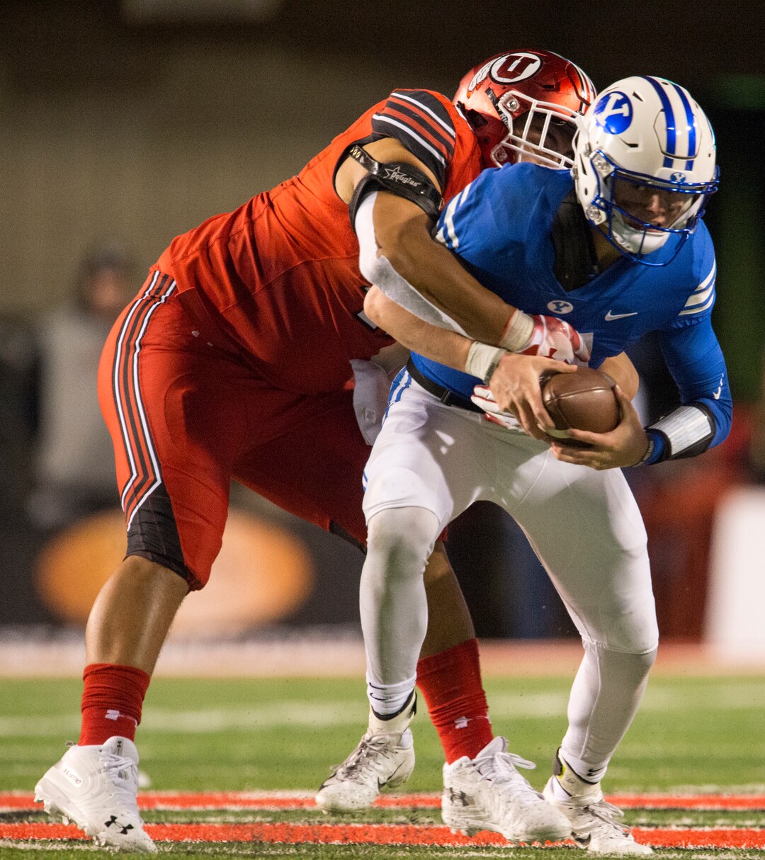 (Rick Egan  |  The Salt Lake Tribune)        Utah Utes defensive tackle Pita Tonga (49) wraps up Brigham Young Cougars quarterback Zach Wilson (11) for a sack,  in football action between the Brigham Young Cougars and the Utah Utes, at Rice-Eccles Stadium, Saturday, November 24, 2018.