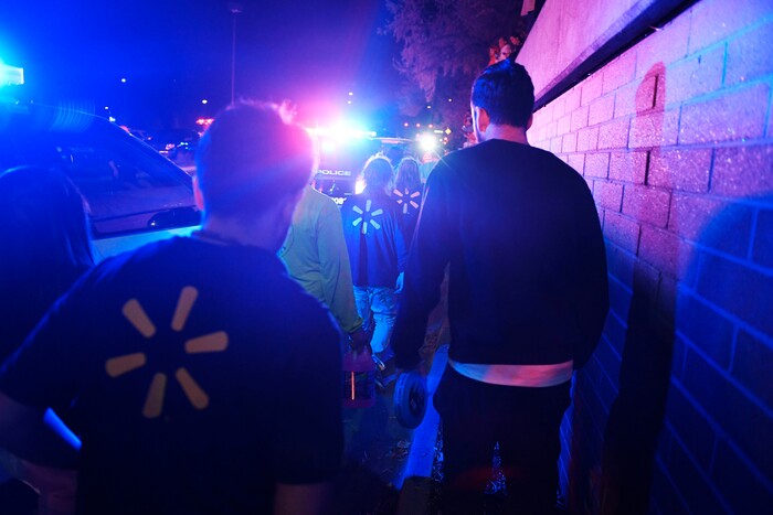 Employees exit the parking lot after a gunman opened fire inside of Walmart in Thornton, Colo., Tuesday, Nov. 1, 2017. Thornton police tweeted Wednesday night that they were responding to a shooting with "multiple parties down." They advised people to stay away from the area as dozens of police cruisers and emergency vehicles raced to the scene. (AAron Ontiveroz/The Denver Post via AP)