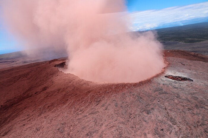 In this photo released by U.S. Geological Survey,  a plume of ash rises from the Puu Oo crater on Hawaii's Kilaueaa Volcano, Thursday, May 3, 2018 in Hawaii Volcanoes National Park. Hawaii's Kilauea volcano erupted Thursday, sending lava shooting into the air in a residential neighborhood and prompting mandatory evacuation orders for nearby homes. Hawaii County said steam and lava poured out of a crack in Leilani Estates, which is near the town of Pahoa on the Big Island. (U.S. Geolgogical Survey via AP)
