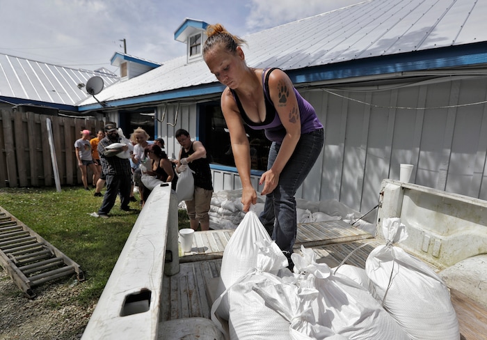 (Chris O'Meara | The Associated Press) Krystal Day, of Homosassa, Fla., leads a sandbag assembly line at the Old Port Cove restaurant Tuesday, Oct. 9, 2018, in Ozello, Fla. Employees were hoping to protect the restaurant as Hurricane Michael continues to churn in the Gulf of Mexico heading for the Florida panhandle.