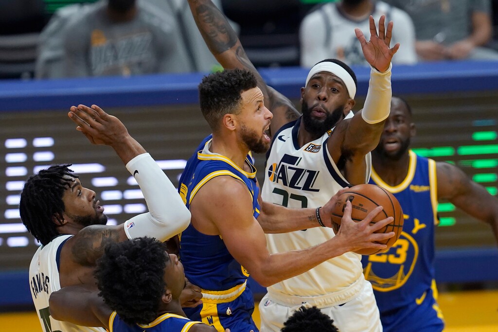 (Jeff Chiu | AP) Golden State Warriors guard Stephen Curry, center, shoots between Utah Jazz center Derrick Favors, left, and forward Royce O'Neale, right, during the first half of an NBA basketball game in San Francisco, Sunday, March 14, 2021.