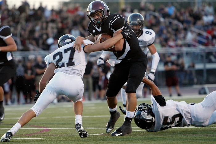 (Chris Detrick  |  The Salt Lake Tribune)  Jordan's Austin Kafentzis (2) runs past Alta's Brandon Smart (27) and Alta's Dylan Rivas (15) during the first half of the game at Jordan High School Friday September 14, 2012.  Jordan is winning the game 20-17.