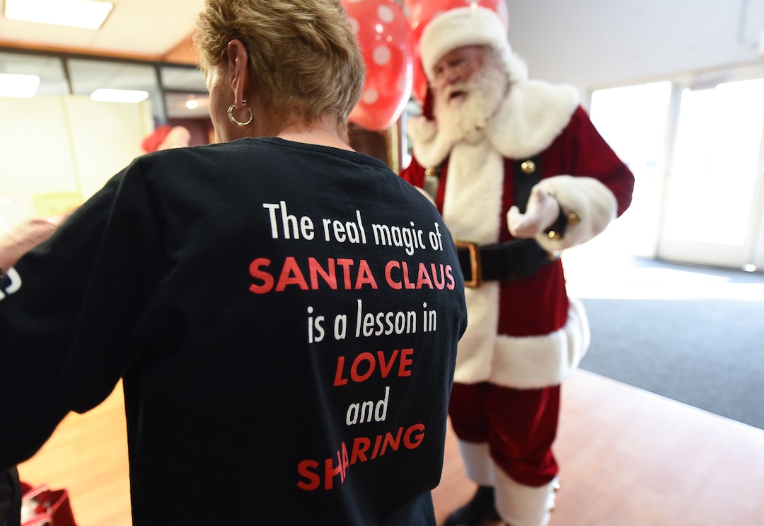 (Francisco Kjolseth  |  The Salt Lake Tribune)  A team of volunteers with the Granite Education Foundation's Santa Sacks program get a boost from Santa, played by Merlin Taylor, as they help bring some holiday magic to children in need. Working with social workers in the district the team is expected to assemble more than 3000 sacks with blankets, books, toys, socks, hats, toothbrushes and school supplies for the younger children or earbuds and gift cards for other students.