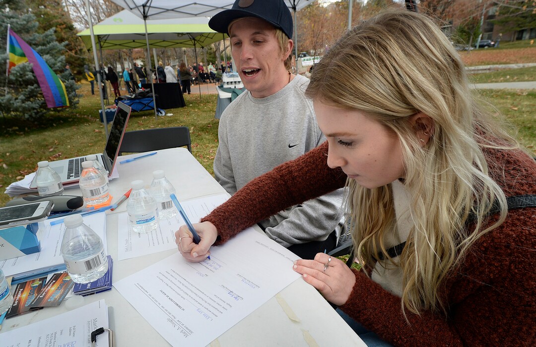 (Scott Sommerdorf   |  The Salt Lake Tribune)   Eliza Long, of Provo, signs papers of resignation from the LDS church alongside her brother Lorenzo, at the 8th annual mass resignation in City Creek Park, Sunday, November 5, 2017. 