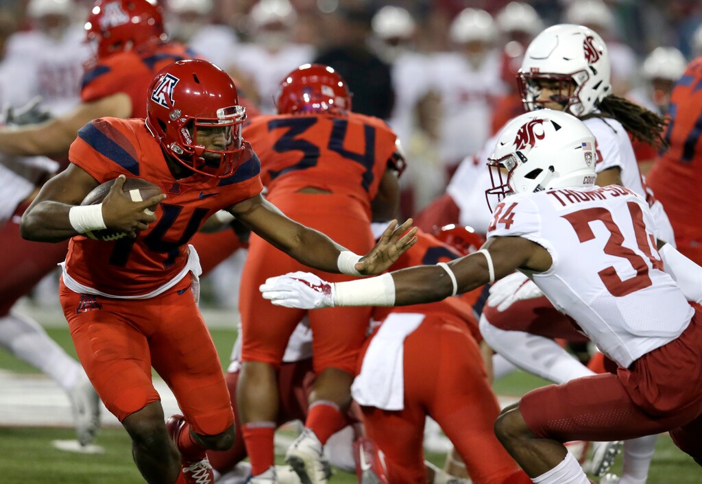 Arizona quarterback Khalil Tate (14) stiff-arms Washington State safety Jalen Thompson (34) in the first half during an NCAA college football game, Saturday, Oct. 28, 2017, in Tucson, Ariz. (AP Photo/Rick Scuteri)