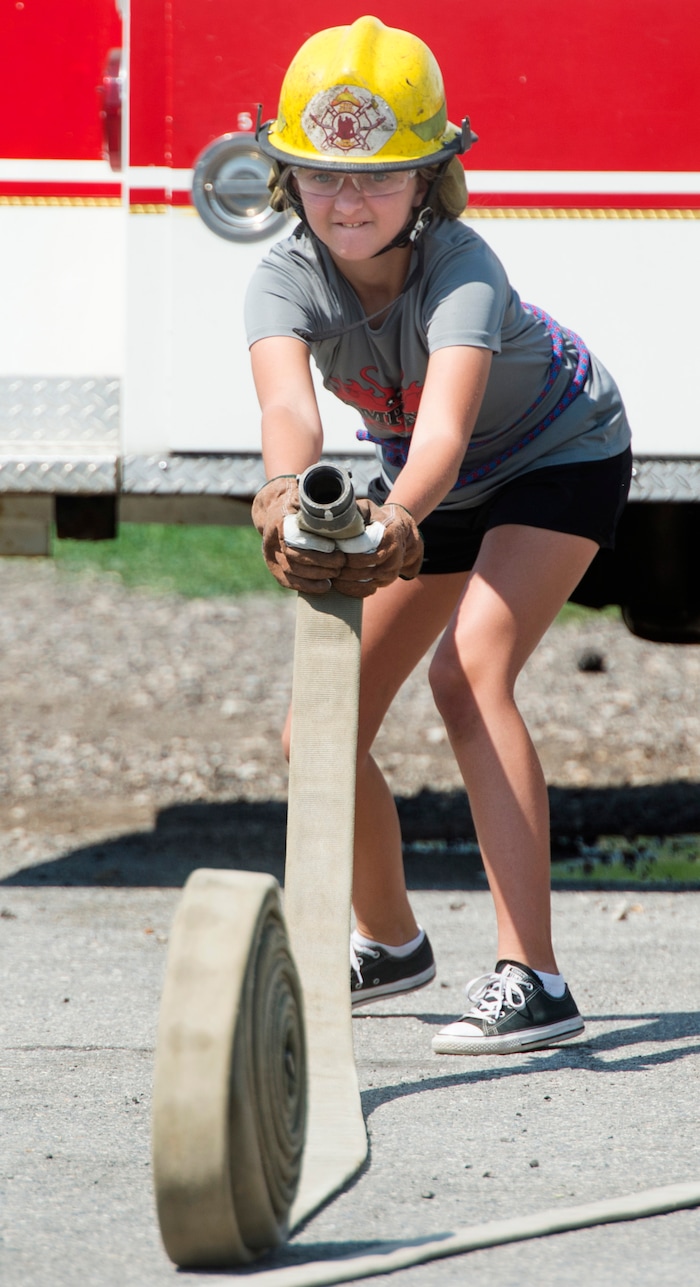 (Rick Egan  |  The Salt Lake Tribune)  Nicole rolls out a hose during a firefighter skills relay, while attending Camp Fury.  A dozen Utah Girl Scouts participated in a 3-day camp led by female firefighters. Camp Fury Utah was developed in partnership with the Girl Scouts and local fire and police departments, designed to expose teen girls to careers in public safety and other non-traditional jobs. Saturday, August 5, 2017.


