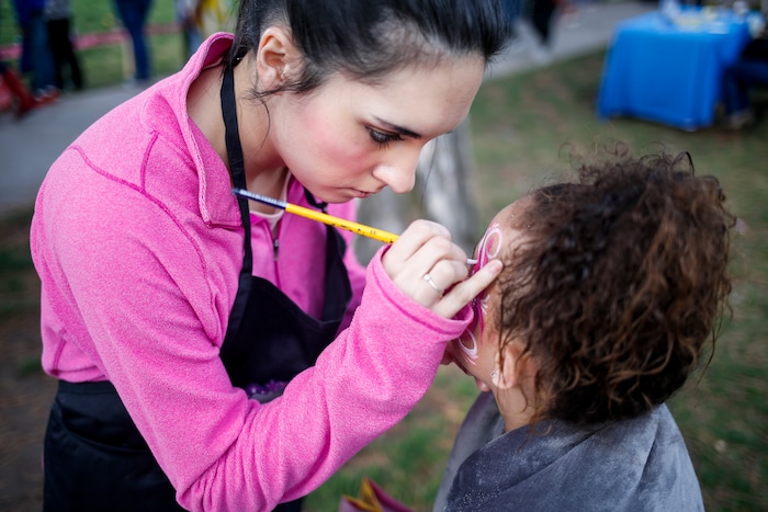 (Nicole Boliaux | For The Tribune) Kailee Brown, left, with My Kids Entertainment paints Aalyah Laeloni Milline's face during the annual Easter egg hunt put on by A Kid's Place Dentistry in Liberty Park in Salt Lake City on Saturday, March 31, 2018.