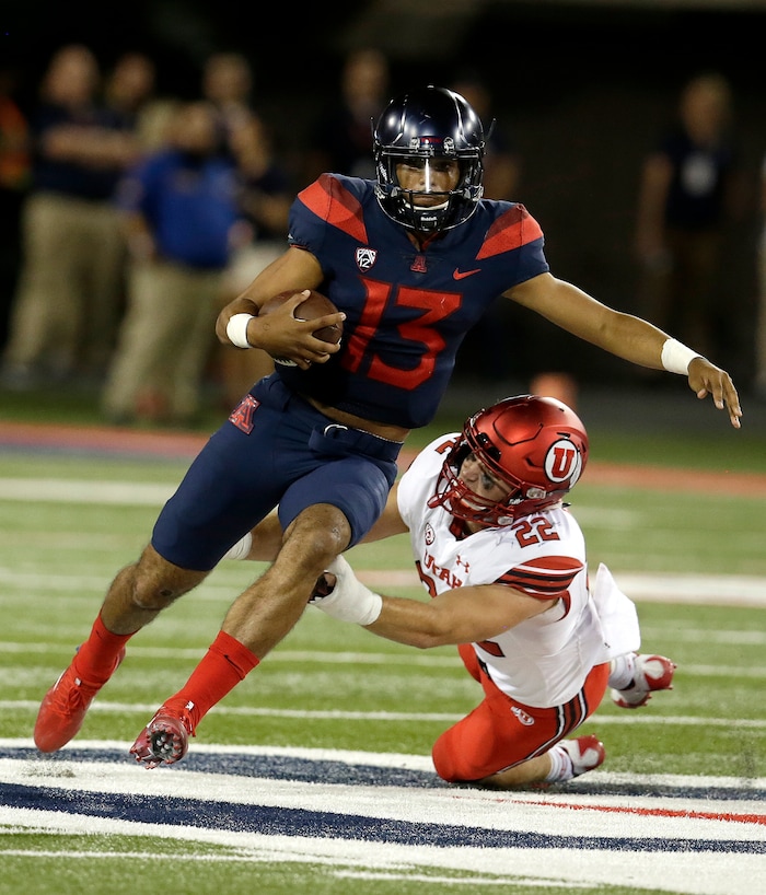 Arizona quarterback Brandon Dawkins (13) breaks a tackle on Utah defensive back Chase Hansen (22) in the second half during an NCAA college football game, Friday, Sept. 22, 2017, in Tucson, Ariz. Utah defeated Arizona 30-24. (AP Photo/Rick Scuteri)