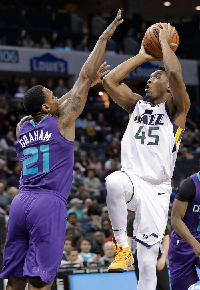Utah Jazz's Donovan Mitchell (45) shoots over Charlotte Hornets' Treveon Graham (21) during the first half of an NBA basketball game in Charlotte, N.C., Friday, Jan. 12, 2018. (AP Photo/Chuck Burton)