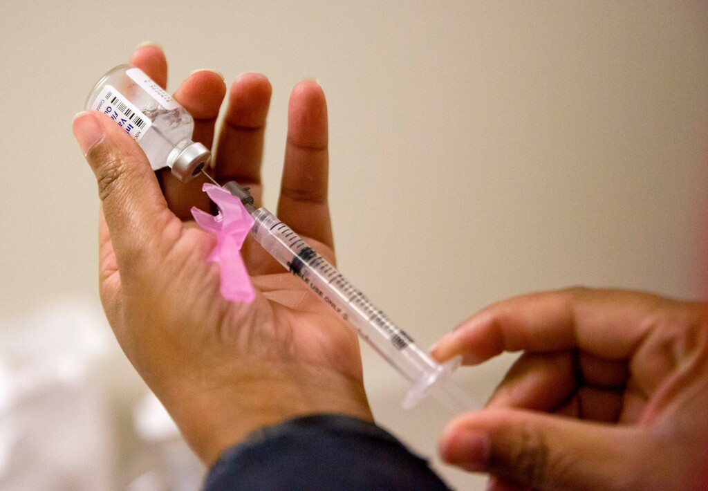 (David Goldman | AP file photo) A nurse prepares a flu shot at the Salvation Army in Atlanta in February 2018.