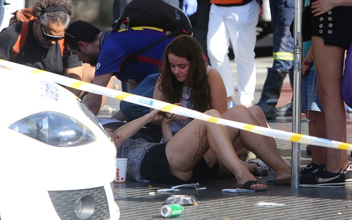(Oriol Duran | The Associated Press) Injured people are treated in Barcelona, Spain, Thursday, Aug. 17, 2017 after a white van jumped the sidewalk in the historic Las Ramblas district, crashing into a summer crowd of residents and tourists and injuring several people, police said.