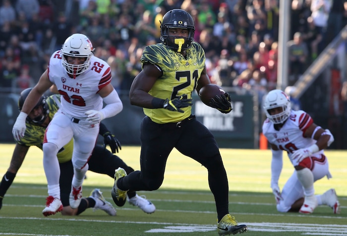 Oregon running back Royce Freeman rushes against Utah's Chase Hansen, left, and Sunia Tauteoli during the second quarter of an NCAA college football game Saturday, Oct. 28, 2017, in Eugene, Ore. (AP Photo/Chris Pietsch)