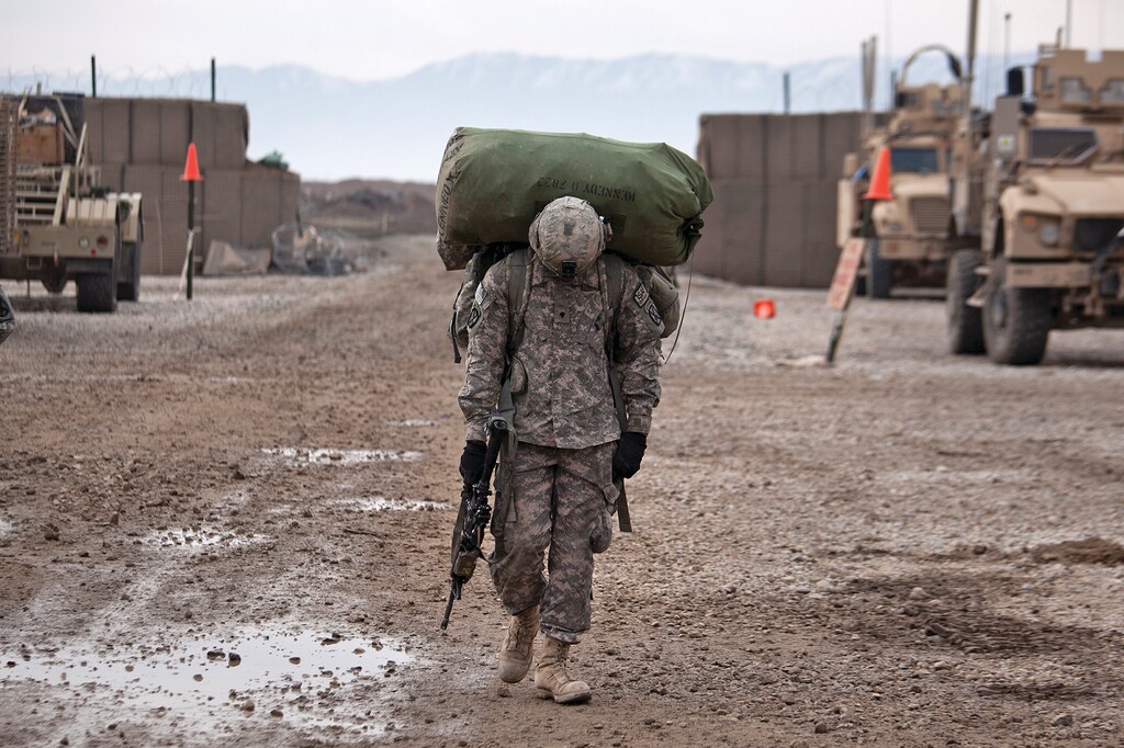 An American soldier carries a duffel bag on his back in Kunduz, Afghanistan, on Feb. 21, 2011. (Damon Winter/The New York Times)