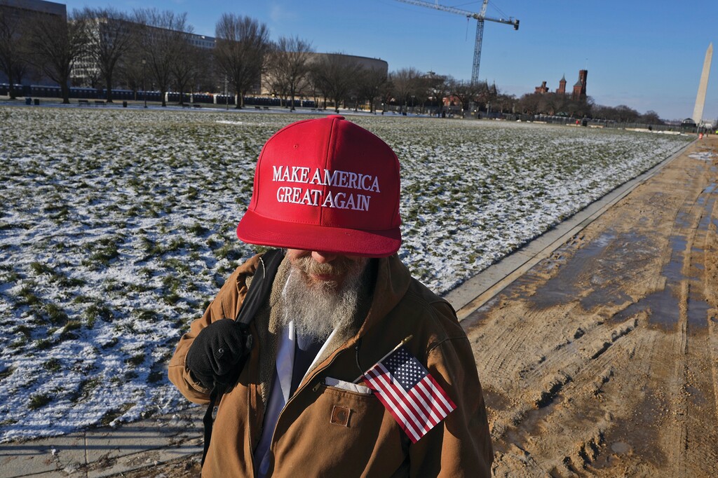 A supporter of President-elect Donald Trump wears an oversized “Make America Great Again” hat on the National Mall in Washington on Monday morning, Jan. 20, 2025. President-elect Donald Trump will be inaugurated inside the Capitol on Monday. (Todd Heisler/The New York Times)