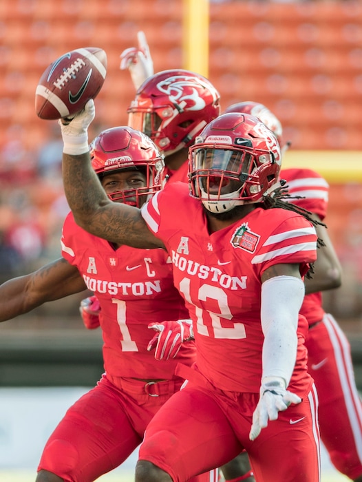 Houston linebacker D'Juan Hines (12) and his teammates celebrate the recovery of a Fresno State fumble in the first half of the Hawaii Bowl NCAA college football game, Sunday, Dec. 24, 2017, in Honolulu. (AP Photo/Eugene Tanner)