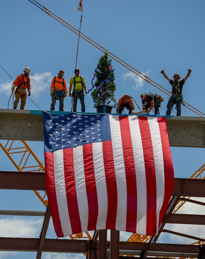 (Leah Hogsten  |  The Salt Lake Tribune) Iron Workers (not in order) Mike Herrera, Chance Bogue, Curtis Loya, Kevin Johnson, Jeff Wilber and Irving Benally with Local Union 27 celebrate the last steel beam with an unfurled American Flag and a tinsel decorated tree during a "topping out" ceremony at the new Salt Lake City International terminal building, Wednesday, May 23, 2018. Such ceremonies can be traced to Scandinavian rites to place a tree atop a new building to appease the tree-dwelling spirits displaced during Construction. Construction is funded by federal grants, user fees, general airport revenue bonds and reserves.