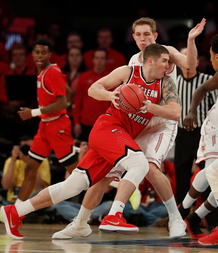 Western Kentucky forward Justin Johnson (23) drives against Utah forward Tyler Rawson (21) during the first half of an NCAA college basketball game in the semifinals of the NIT, Tuesday, March 27, 2018, in New York. (AP Photo/Julie Jacobson)