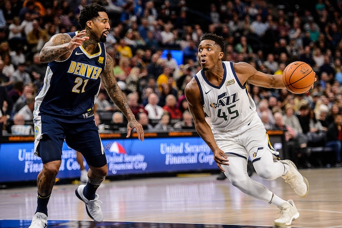 (Trent Nelson | The Salt Lake Tribune)  Utah Jazz guard Donovan Mitchell (45) drives on Denver Nuggets forward Wilson Chandler (21) as the Utah Jazz host the Denver Nuggets, NBA basketball in Salt Lake City, Wednesday October 18, 2017.