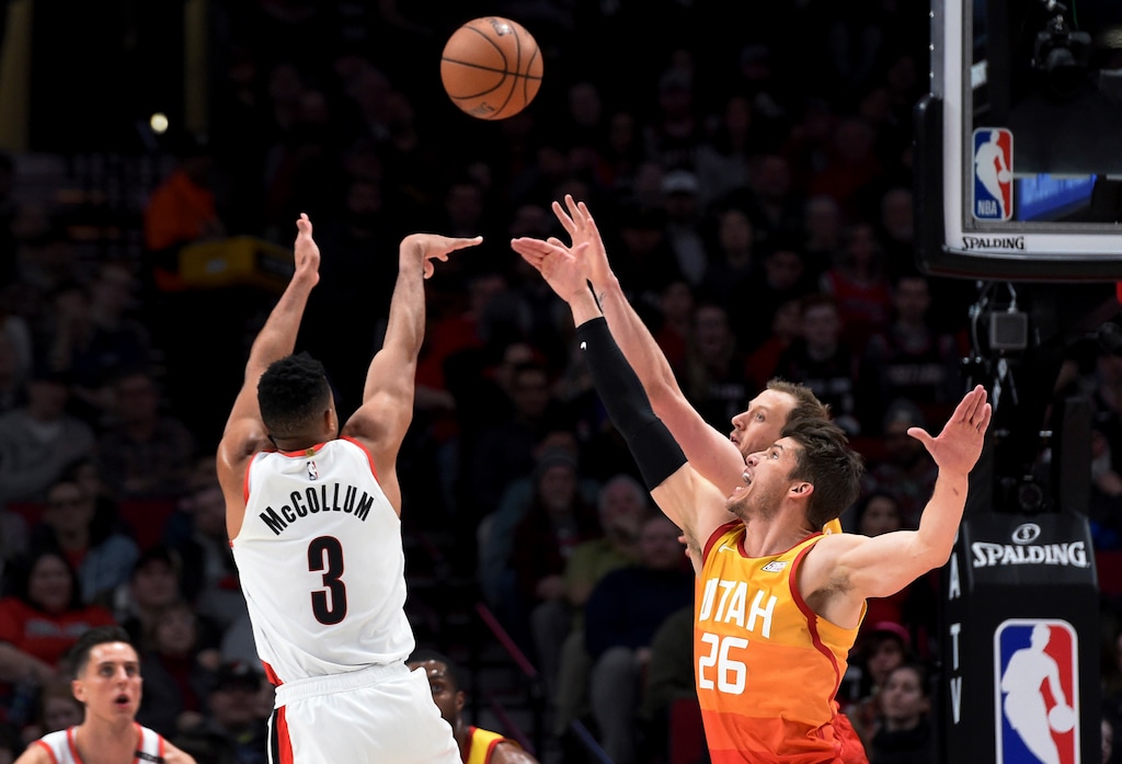 Portland Trail Blazers guard CJ McCollum, left, hits a shot over Utah Jazz forward Joe Ingles, right rear, and guard Kyle Korver (26) during the first half of an NBA basketball game in Portland, Ore., Wednesday, Jan. 30, 2019. (AP Photo/Steve Dykes)