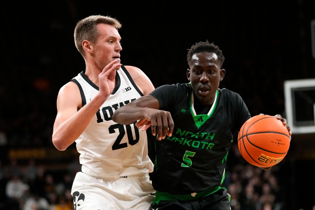 (Charlie Neibergall | AP) North Dakota forward Deng Mayar (5) drives past Iowa forward Payton Sandfort (20) during the first half of an NCAA college basketball game, Tuesday, Nov. 7, 2023, in Iowa City, Iowa.