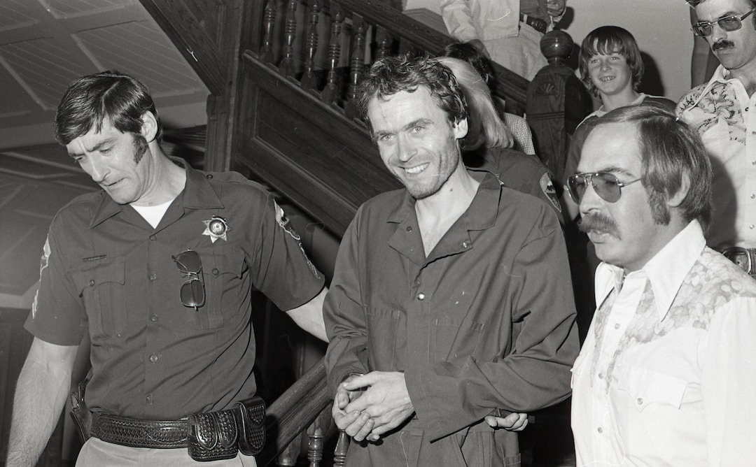 (Glenwood Springs Post Independent file photo via Associated Press) In this 1977 photo, serial killer Ted Bundy, center, is escorted out of court in Pitkin County, Colo. The Glenwood Springs Post-Independent discovered the 40-year-old photo of Bundy, along with other images, that had been locked in an old safe in the newsroom. A local locksmith had volunteered to open it. The photos show Bundy in custody in 1977, the year he escaped from local law enforcement twice while awaiting a murder trial. After his second escape, he fled to Florida, where he killed additional women and was eventually executed in 1989.