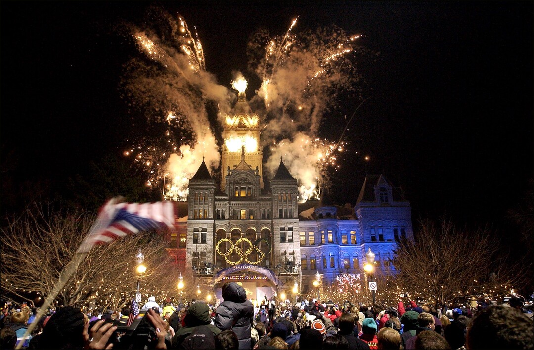 (Rick Egan  |  Tribune file photo) Thousands of fans reveled while fireworks exploded above the City and County Building in 2002 to welcome the Olympic torch relay to Salt Lake City, while giant portraits of athletes graced the sides of downtown buildings and helped create a festive atmosphere.