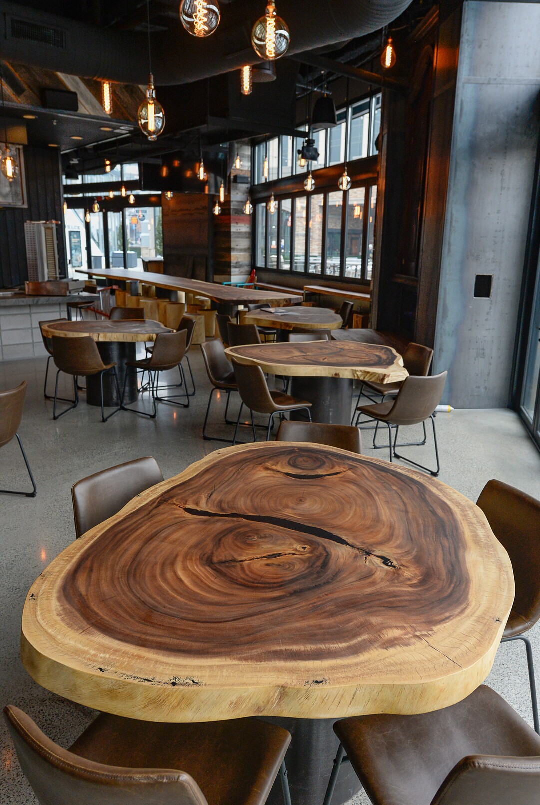 (Francisco Kjolseth  |  The Salt Lake Tribune)  Guests can linger at the long communal tables made from acacia wood from Thailand inside HallPass, the new food hall at The Gateway.